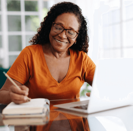 a black american elderly lady smiling anand filling a form